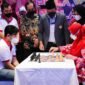 Wali Kota Bandarlampung Eva Dwiana (kanan) membuka Chess Invitation 2022 dengan langkah bidak pertama melawan Grandmaster Catur Novendra (kiri) disaksikan Ketua Percasi Bandarlampung Wilson (tengah) di Hotel Sheraton, Minggu (23/1). Foto: Netizenku.com