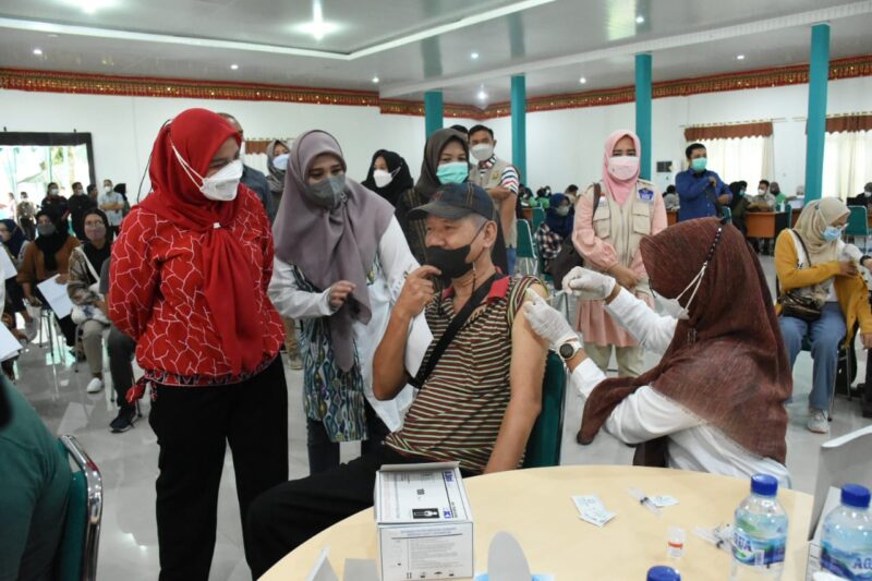 Wali Kota Bandarlampung Eva Dwiana menyaksikan vaksinasi booster kepada salah satu sivitas akademika Unila, Eddy Rifai, di GSG Unila, Minggu (20/2). Foto: Ist