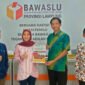 Anggota Bawaslu Kota Bandarlampung Yahnu Wiguno Sanyoto menyerahkan Laporan Tahunan Divisi Penanganan Pelanggaran Tahun 2021 kepada Ketua Bawaslu Provinsi Lampung Fatikhatul Khoiriyah, Selasa (8/3). Foto: Dok. Bawaslu Bandarlampung