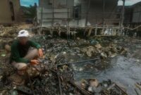 Salah satu warga Kelurahan Panjang Selatan menunjukkan perairan laut Lampung yang tercemar di Kecamatan Panjang, Bandarlampung, Selasa (8/3). Foto: IST