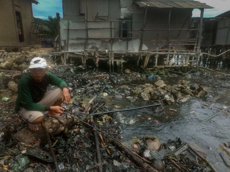 Salah satu warga Kelurahan Panjang Selatan menunjukkan perairan laut Lampung yang tercemar di Kecamatan Panjang, Bandarlampung, Selasa (8/3). Foto: IST