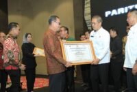 Sekretaris Daerah (Sekda) Kabupaten Tubaba, Novriwan Jaya, menerima penghargaan Paritrana Award  2023 dari Sekdaprov Lampung, Fahrizal Darminto, di Ballroom Hotel Novotel, Bandarlampung, Rabu (22/5/2024). (Arie/NK)