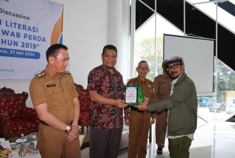 Prof. Dr. Bujang Rahman saat menerima plakat dari Ketua AMSI Wilayah Lampung, Hendri Std.