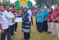 Kepala BNN Kabupaten Tanggamus, Diani Indramaya, menyerahkan SK Desa Bersinar Kabupaten Tanggamus dalam gelaran peringatan Hari Anti Narkotika. (Rapik/NK)