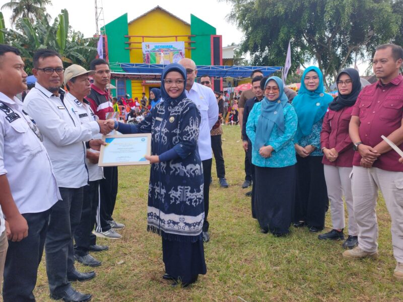 Kepala BNN Kabupaten Tanggamus, Diani Indramaya, menyerahkan SK Desa Bersinar Kabupaten Tanggamus dalam gelaran peringatan Hari Anti Narkotika. (Rapik/NK)