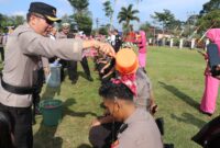 Kapolres Lampung Barat AKBP Ryky Widya Muharam, melakukan prosesi mandi kembang atas kenaikan pangkat 16 personelnya. (Iwan/NK)