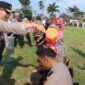 Kapolres Lampung Barat AKBP Ryky Widya Muharam, melakukan prosesi mandi kembang atas kenaikan pangkat 16 personelnya. (Iwan/NK)