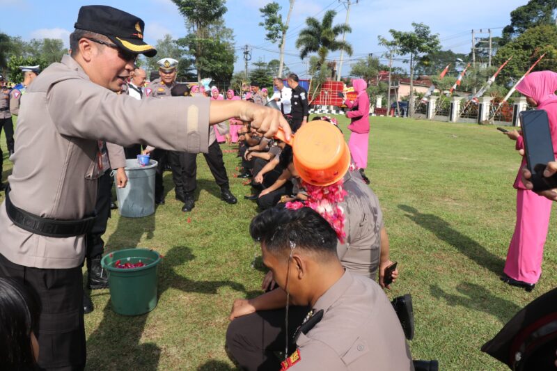 Kapolres Lampung Barat AKBP Ryky Widya Muharam, melakukan prosesi mandi kembang atas kenaikan pangkat 16 personelnya. (Iwan/NK)