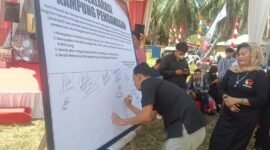 Koordinator Divisi Pencegahan Bawaslu Kota Bandarlampung, Muhamad Muhyi, ketika menandatangani kesepakatan deklarasi kampung pengawasan. (Foto: Luki)