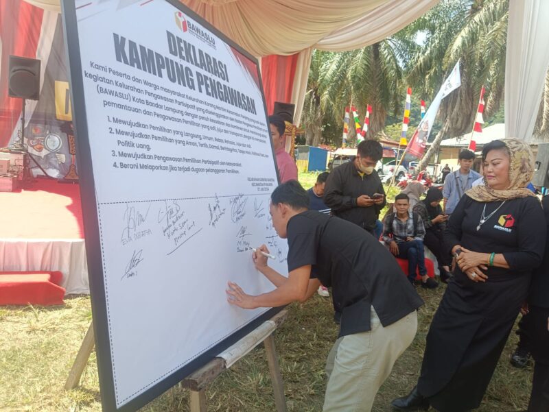 Koordinator Divisi Pencegahan Bawaslu Kota Bandarlampung, Muhamad Muhyi, ketika menandatangani kesepakatan deklarasi kampung pengawasan. (Foto: Luki)