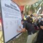 Koordinator Divisi Pencegahan Bawaslu Kota Bandarlampung, Muhamad Muhyi, ketika menandatangani kesepakatan deklarasi kampung pengawasan. (Foto: Luki)