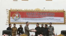 Sekdakab Tubaba Novriwan Jaya,  menyerahkan rancangan KUA PPAS tahun anggaran 2025 kepada Wakil Ketua I DPRD  Busroni, dalam rapat paripurna, Panaragan (9/7/2024). (Arie/NK)