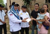 Ketua DPK Apdesi Kecamatan Talangpadang, saat menyerahkan bantuan dana tunai kepada Taufik, warga Pekon Sinar Petir yang rumahnya ludes dalam musibah kebakaran beberapa hari lalu. (Rapik/NK)