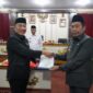 Pj Bupati Tanggamus, Mulyadi Irsan, saat memberikan Surat Keputusan (SK) Pelaksana Harian Sekretaris Daerah Kabupaten Tanggamus kepada Suaidi. (Ist/NK)