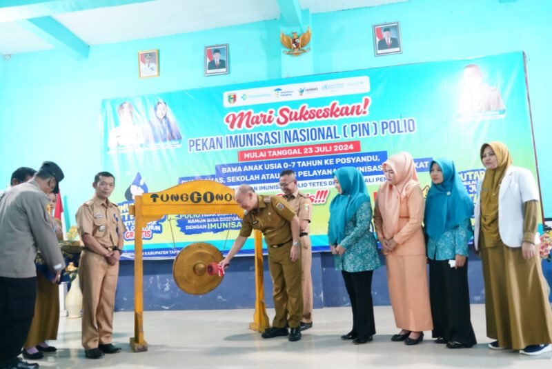 Pj Bupati Mulyadi Irsan, pukul gong sebagai penanda dimulainya Pekan Imunisasi Nasional Polio di Kabupaten Tanggamus, Sumberejo Selasa (23/7/2024). (Rapik/NK)