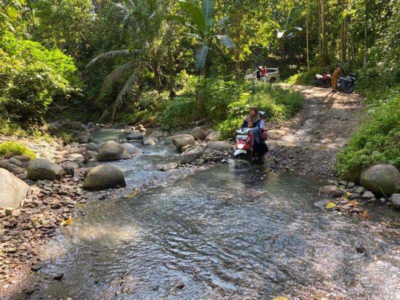 Warga Dusun Pancur Desa Hurun beraktivitas melintasi sungai tanpa jembatan. (Ist/NK)