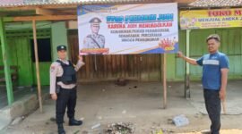 Personel Polres Pringsewu memasang banner imbauan bahaya judi online dan offline. (Ist/NK)