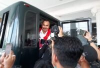 Tersangka Mantan Kepala Bapenda Kabupaten Pringsewu, WJS, tersenyum saat menaiki mobil tahanan Kejari Pringsewu. (Ist/NK) 