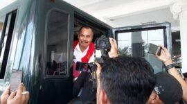 Tersangka Mantan Kepala Bapenda Kabupaten Pringsewu, WJS, tersenyum saat menaiki mobil tahanan Kejari Pringsewu. (Ist/NK) 