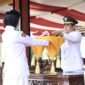 Pj. Bupati Tubaba Drs. M. Firsada, M.Si menyerahkan Sang Saka Merah Putih kepada Paskibraka Tubaba untuk di kibarkan, Sabtu (17/8/2024). (Ist/NK)
