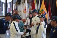 Penjabat Gubernur Lampung Samsudin, melakukan pemasangan atribut secara simbolis kepada kontingen Lampung yang akan mengikuti PON XXI di Medan-Aceh. (Iwan/NK)