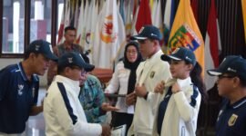 Penjabat Gubernur Lampung Samsudin, melakukan pemasangan atribut secara simbolis kepada kontingen Lampung yang akan mengikuti PON XXI di Medan-Aceh. (Iwan/NK)