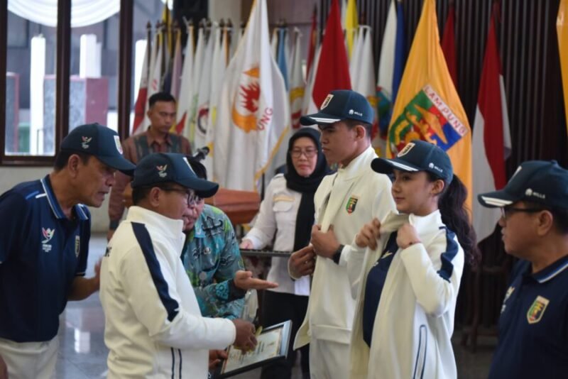 Penjabat Gubernur Lampung Samsudin, melakukan pemasangan atribut secara simbolis kepada kontingen Lampung yang akan mengikuti PON XXI di Medan-Aceh. (Iwan/NK)