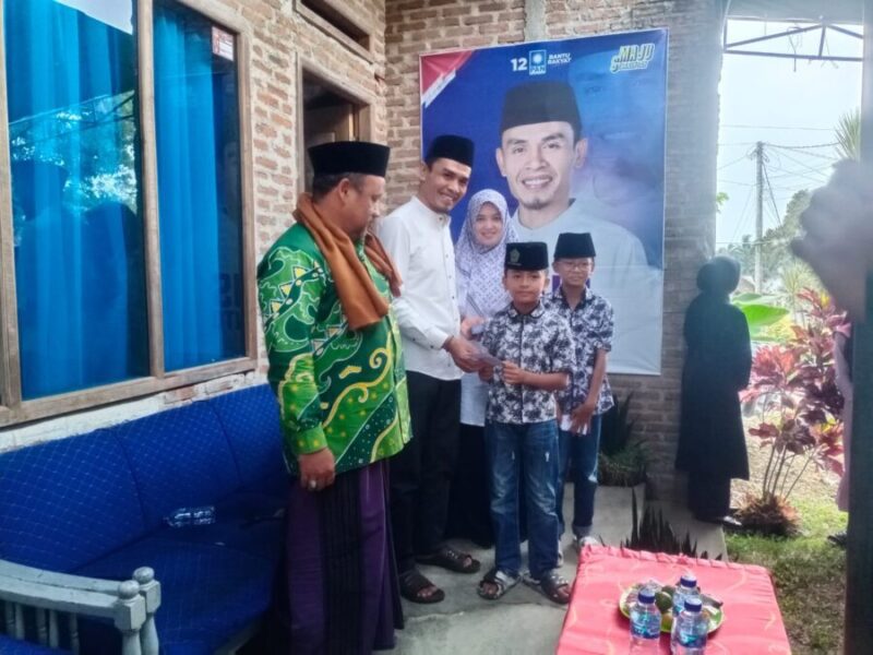 Sekretaris DPD PAN Kabupaten Tanggamus, Agus Suranto (kemeja putih) bersama Istri, saat memberikan santunan yang digagas Ketua DPD PAN Tanggamus, Tedi Kurniawan. (Rapik/NK)