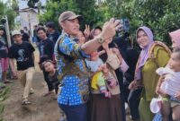 Sejumlah masyarakat Pekon Hanakau berfoto selfi dengan Calon bupati Lampung Barat Parosil Mabsus, saat menyapa masyarakat setempat, Sabtu (21/9/2024). (Iwan/Nk)