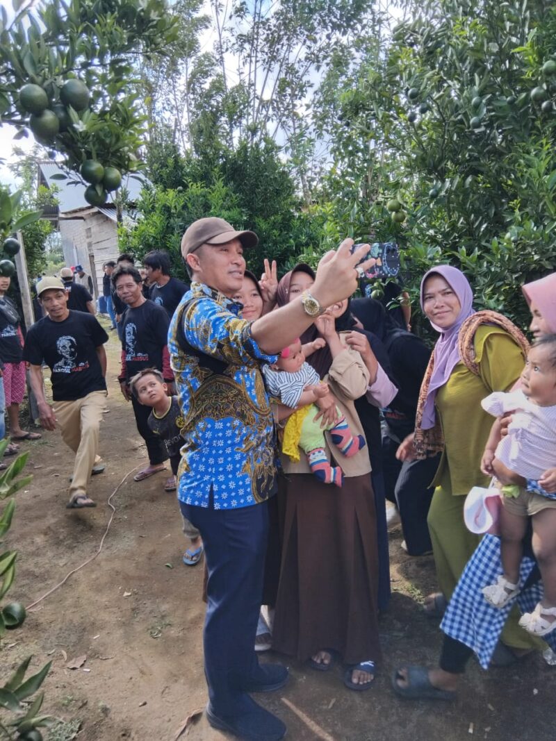 Sejumlah masyarakat Pekon Hanakau berfoto selfi dengan Calon bupati Lampung Barat Parosil Mabsus, saat menyapa masyarakat setempat, Sabtu (21/9/2024). (Iwan/Nk)