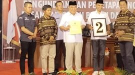 Pleno pengundian nomor urut; H. Moh Saleh Asnawi Calon Bupati (ketiga dari kiri) bersama Agus Suranto Calon Wakil Bupati (kedua dari kanan) saat memperlihatkan salinan SK pleno penetapan nomor urut dan nomor urut 2, yang diserahkan KPUD Tanggamus, Senin (23/9). (Rapik/Nk)