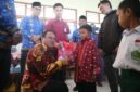 Penjabat bupati Lampung Barat, Nukman membagikan bantuan seragam gratis kepada siswa-siswi di Lampung Barat. (Iwan/Nk)