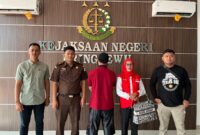  Tersangka kasus pembunuhan, Arfan Gunawan (27) didampingi Penyidik Satuan Reserse Kriminal (Satreskrim) Polres Pringsewu saat berada di Kejaksaan Negeri Pringsewu, Selasa (15/10/2024).