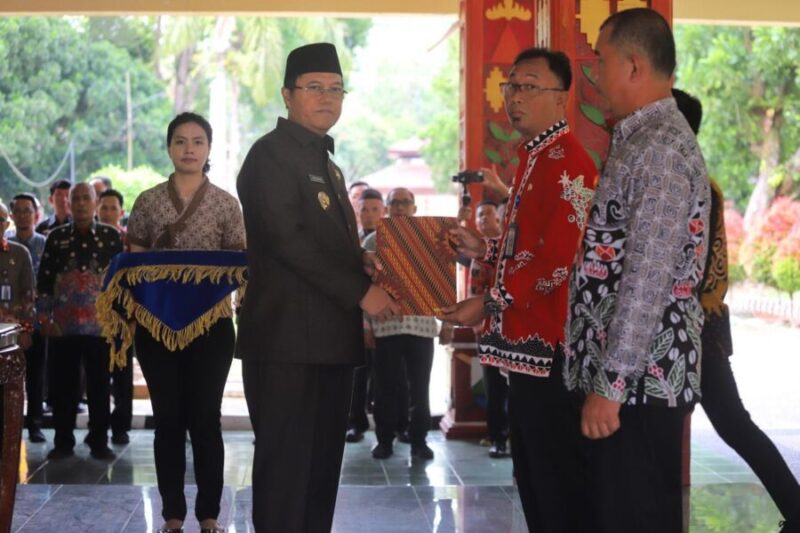 Penjabat bupati Lampung Barat, Nukman, menyerahkan SK pengangkatan PLT Kadis BKAD dan Inspektur. (Ist/NK)