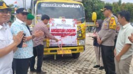 Pj bupati Lampung Barat Nukman dan Kapolres AKBP Rinaldo Aser menyaksikan pemotongan pita sebagai tanda pelepasan kendaraan distribusi logistik Pilkada, Minggu (24/11/2024). (Iwan/Nk)
