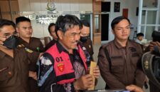 Sekretaris Kabupaten Pringsewu, Heri Iswahyudi, tersenyum lebar pasca ditetapkan tersangka korupsi dana hibah LPTQ 2022. (Ist/Netizenku) 