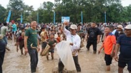 Keseruan warga Pringsewu saat berebut ikan lele pada acara Gogoh Iwak, di Komplek Perkantoran Pemkab Pringsewu, Minggu (13/4/2025), Foto: Reza/NK.