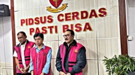 Tiga tersangka berbaris di depan slogan 