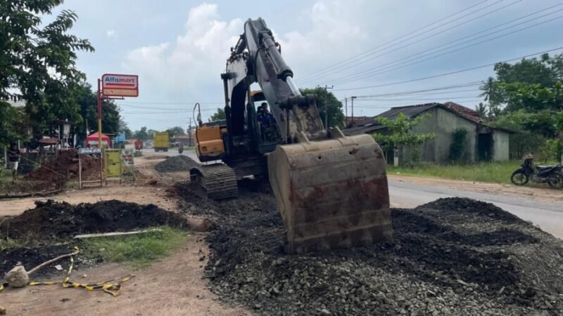 Proses pengerjaan pelebaran jalan pada ruas Simpang PU Candra Mukti – Eks Pasar Tempel depan Samsat Tubaba (025) di Tiyuh Candra Mukti, Jumat (5/12/2025). Foto: Arie/NK.