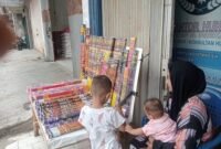 Namanya Dini. Ibu muda dengan dua anak yang masih kecil-kecil. Sore itu, Selasa, 30 Desember 2025, ia berdiri di depan kantor media online Sinar Lampung di Jalan Malahayati, Teluk Betung, Bandar Lampung. 