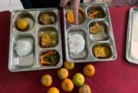 Seorang guru memperlihatkan perbedaan porsi bernilai Rp2000 hanya terletak pada kepalan nasi yang berukuran sedikit lebih besar. (Foto: Netizenku)