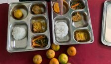 Seorang guru memperlihatkan perbedaan porsi bernilai Rp2000 hanya terletak pada kepalan nasi yang berukuran sedikit lebih besar. (Foto: Netizenku)