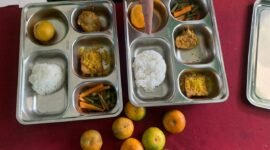 Seorang guru memperlihatkan perbedaan porsi bernilai Rp2000 hanya terletak pada kepalan nasi yang berukuran sedikit lebih besar. (Foto: Netizenku)